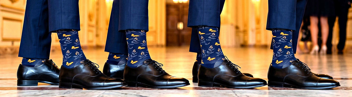 Men in suits wearing navy Butterfly organic cotton dress socks, Love Sock Company