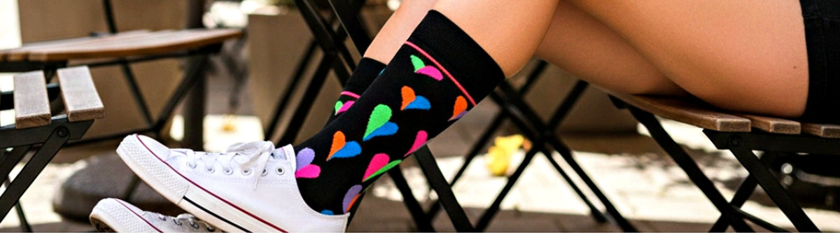 Woman wearing Funky Hearts black crew socks with white sneakers, Love Sock Company